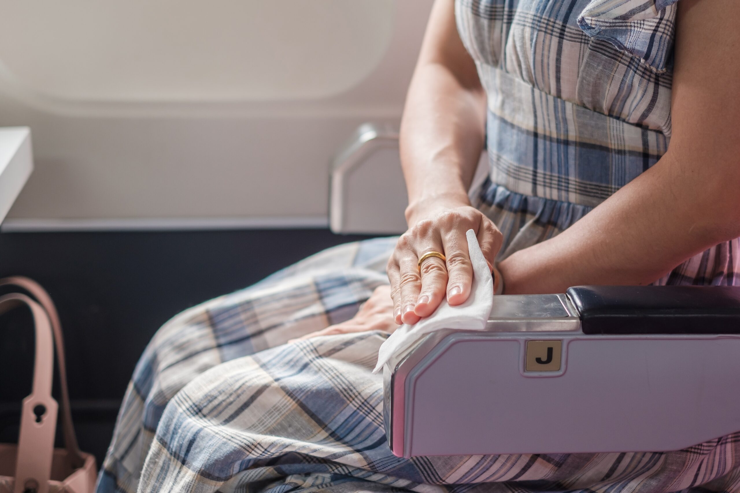 A person using sanitizing wipes on an airplane