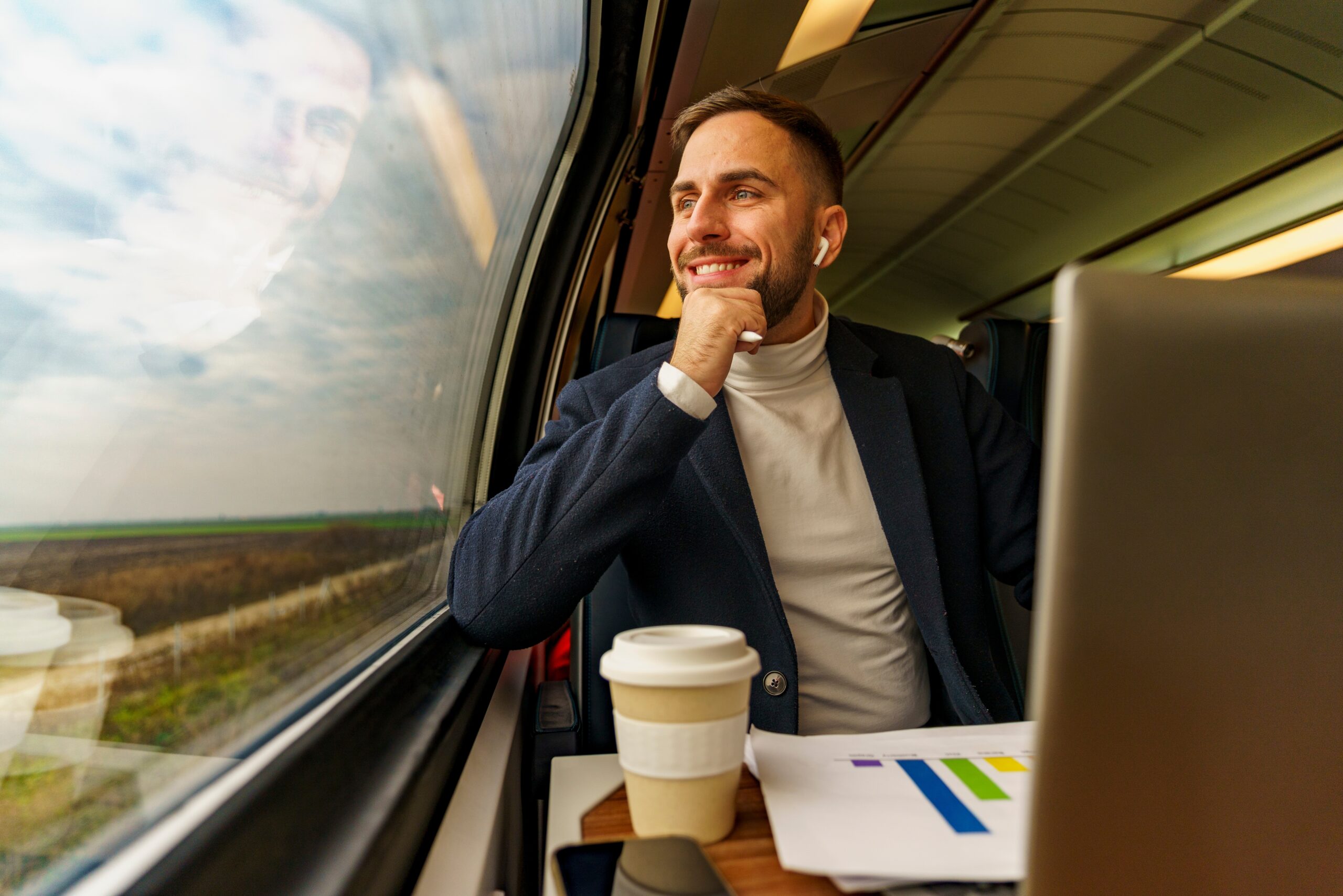 A passenger drinking coffee from a sustainable paper cup on a train